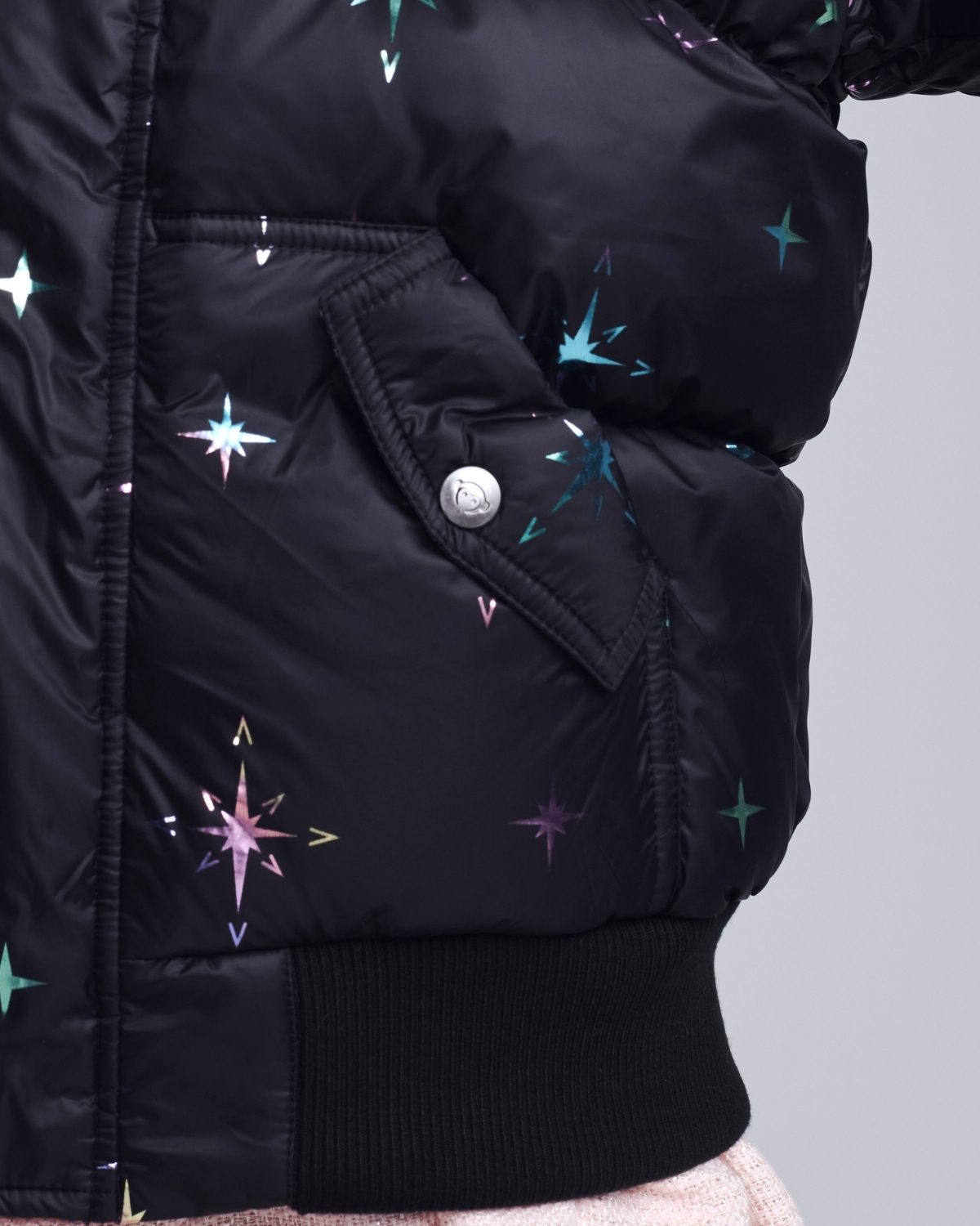 Black puffer jacket with star patterns on a gray background