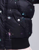 Black puffer jacket with star patterns on a gray background
