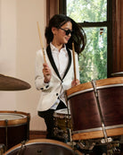 A child wearing an ivory tuxedo jacket, playing drums, alternate view. Appaman Fall/Winter 2026 collection.