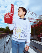 Child holding a foam finger with the number one outdoors