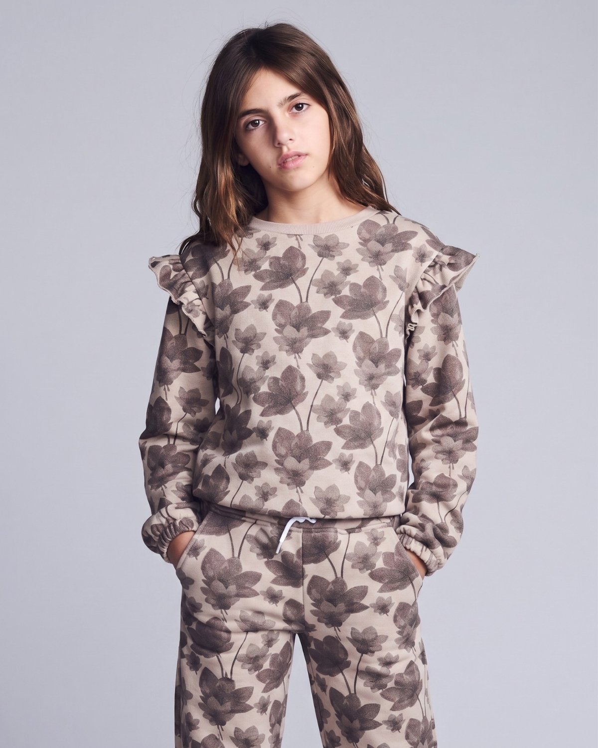 Person wearing a floral patterned outfit on a plain background