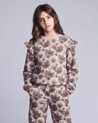 Person wearing a floral patterned outfit on a plain background