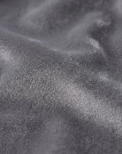 A close-up of a dark gray plush fabric texture with soft folds and a fine looped pile.