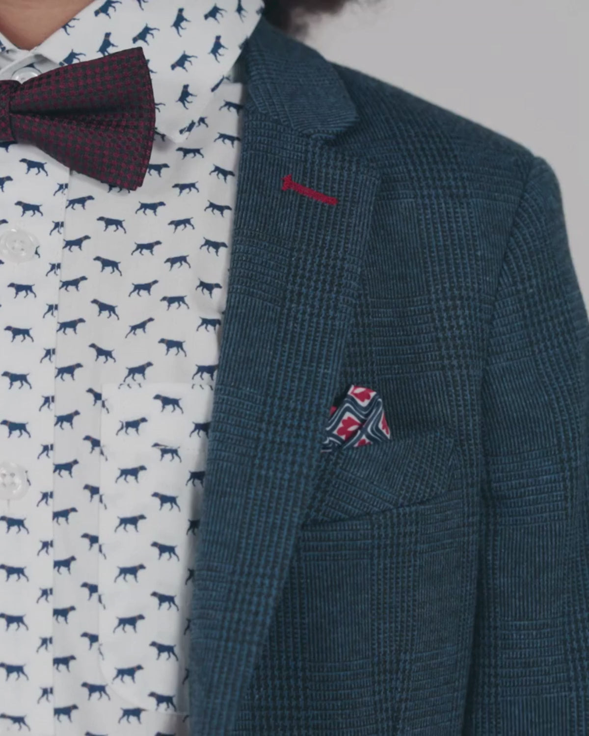 Close-up of boy's blazer with Indigo Wales Check Stretchy Suit Pants, featuring a patterned shirt and bow tie.